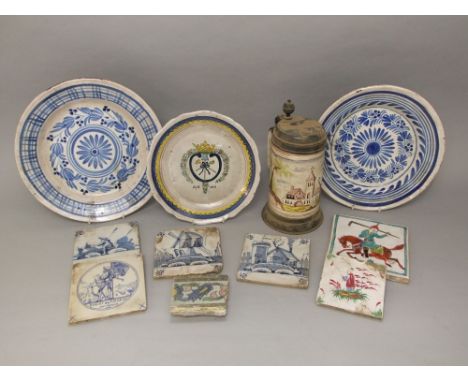 A collection of continental tin glazed earthenwares including a tankard with painted church decoration and pewter mounts, a 1