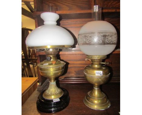 A Victorian brass oil lamp with ceramic base, wheat ear detail and domed milk glass shade, together with one other  