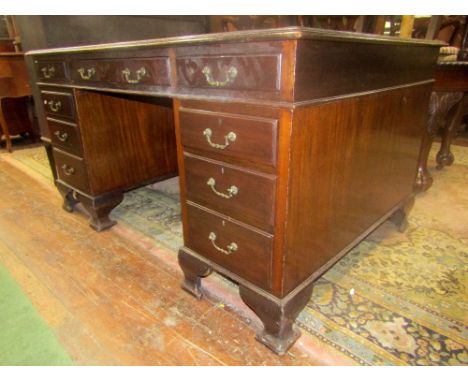 A Georgian style partners desk, each side enclosing an arrangement of graduated drawers, with cast brass fittings, inset leat