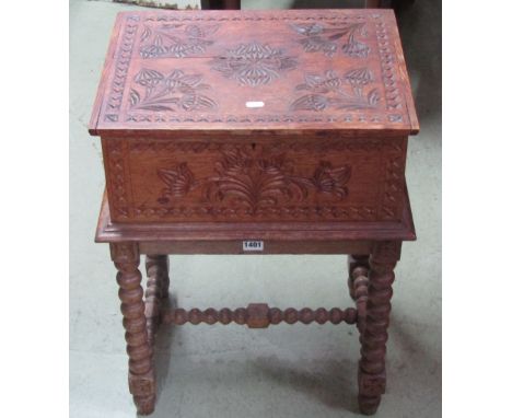 A medium to light oak box and stand with chip carved foliate and geometric detail raised on turned bobbin supports and stretc
