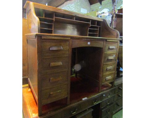 An early 20th century oak desk roll top, the S shaped tambour roll enclosing a simply fitted interior over a central kneehole