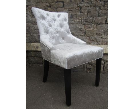 A set of six contemporary button back dining chairs in plush silver velvet raised on ebonised square cut legs, fitted with a 