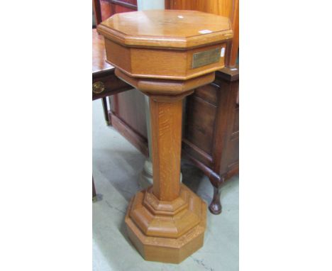 An ecclesiastical medium to light oak floorstanding font of octagonal form, the removable lid enclosing a shallow circular pr