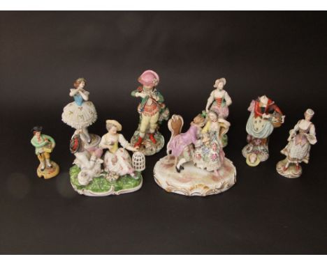 A group of mainly 19th century continental figures including a pair of lovers seated on armchairs, raised on oval base and wi