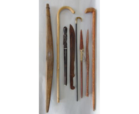 A mixed collection of walking canes, together with a large rosewood page turner and plaited leather whip (8)