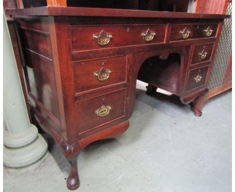 An Edwardian kneehole writing desk of rectangular form with green inset faux leather top over an arrangement of six frieze dr