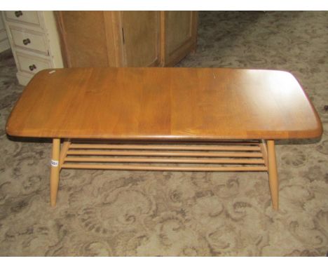 An Ercol light elm and beechwood coffee table of rectangular form with moulded outline and rounded corners, raised on splayed