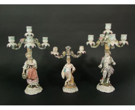A pair of 19th century four branch candelabra, the columns with applied figures of male and female characters, 41 cm tall, to