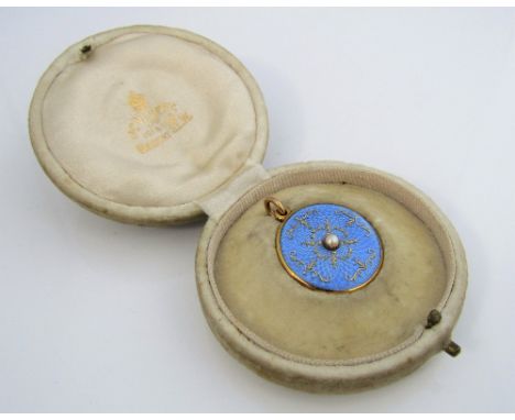 An Edwardian 15ct circular locket set with a central split pearl to a pale blue guilloche enamel ground, with intricate quatr