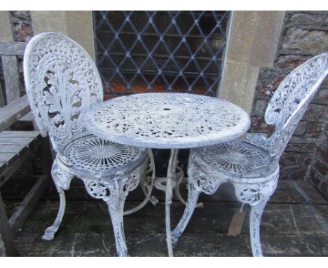 A Victorian style cast aluminium garden terrace table with decorative circular pierced top raised on swept tripod supports to