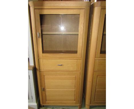 A pair of contemporary light oak freestanding side cabinets, each enclosed by an arrangement of two doors and central drawer,