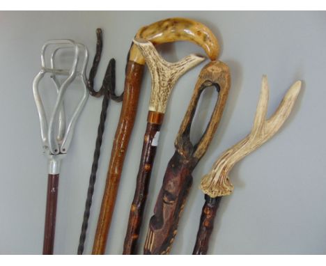 A mixed collection of canes to include walking staffs, a shooting stick, a tribal stick and others (6)