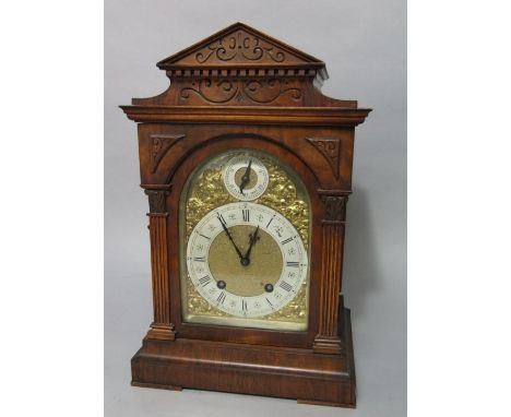 A German walnut two train bracket clock, the arched gilt face with subsidiary slow/fast dial, the silvered chapter ring with 