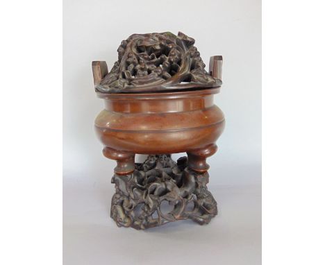 Impressive antique Chinese bronze sensor, with seal mark to base and three typical shaped feet, with carved hardwood base and