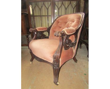 A Victorian spoonback drawing room chair with upholstered seat and button back with a carved show wood frame, raised on shape