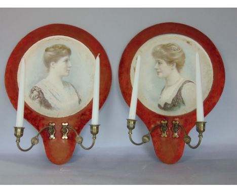 A pair of twin sconce Girondles, fitted onto a baize frame and with ceramic plates decorated with the busts of young ladies, 