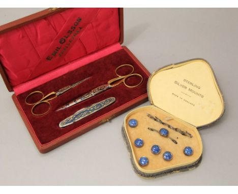 A cased set of silver mounted dress studs with speckled ceramic panels and a cased Swedish set comprising two scissors, (larg