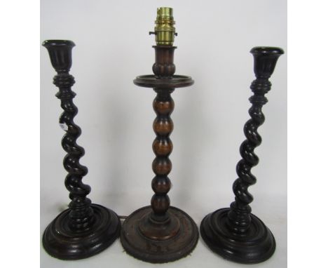 Pair of carved oak barley twist candlesticks, together with a further oak bobbin turned table lamp (3)