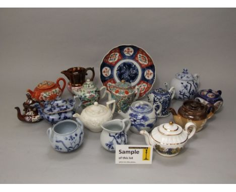 A collection of oriental and other teapots including a blue and white example, famille rose example, etc, together with three