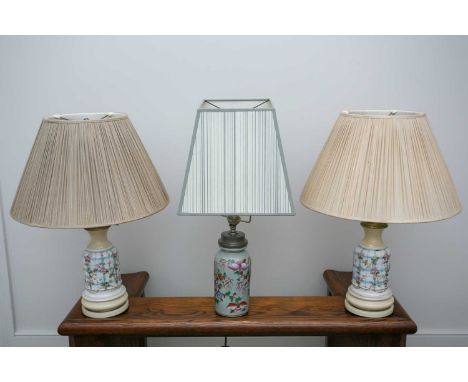 A pair of French faux oil porcelain table lamps, fitted for electricity with rise and fall pleated shades, together with anot