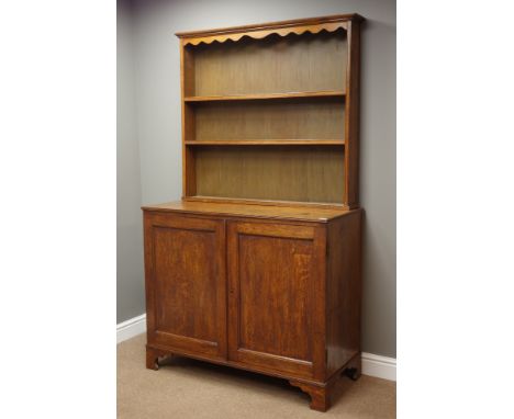 Late 18th century oak dresser, raised two tier plate rack with moulded cornice and shaped frieze, base with two panel doors o