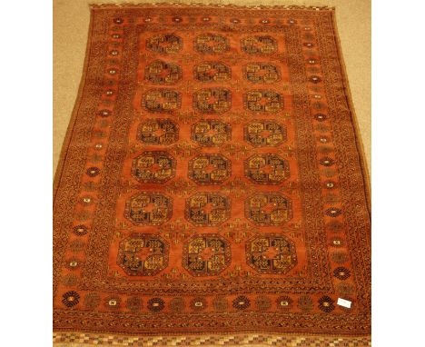 Persian Bokhara pale red ground rug carpet, with blue Guls and stylised flower heard border, 295cm x 206cm   Condition Report