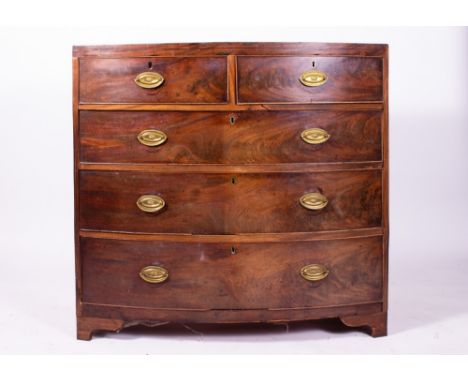 A GEORGE III MAHOGANY BOW FRONTED CHEST OF TWO SHORT AND THREE LONG DRAWERS with oval brass handles and short bracket feet, 1