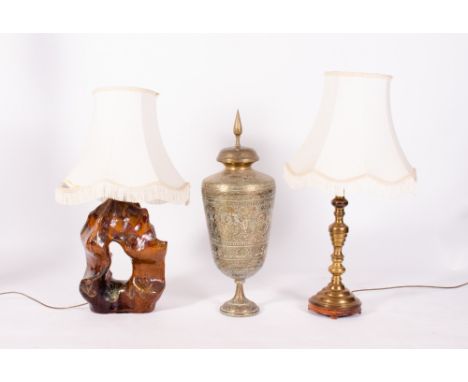 AN EASTERN BRASS VASE AND COVER decorated with flowers, figures and hounds, 68cm in height together with a brass table lamp; 