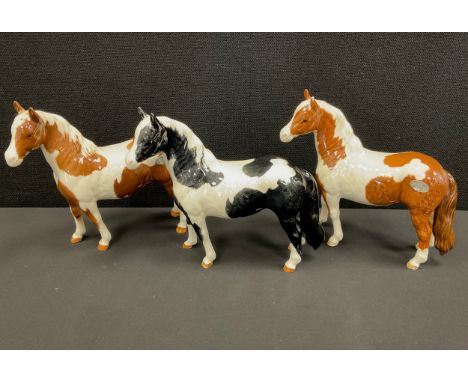 Beswick ponies including; Skewbald and Piebald, 17cm high (3)