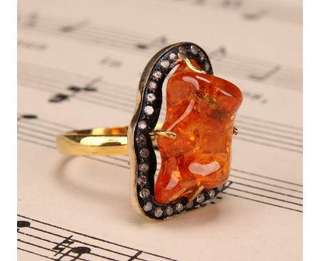 An 18ct gold and silver topped ring set with a freeform mandarin garnet surrounded vby rose cut diamonds, garnet 15.86ct, dia