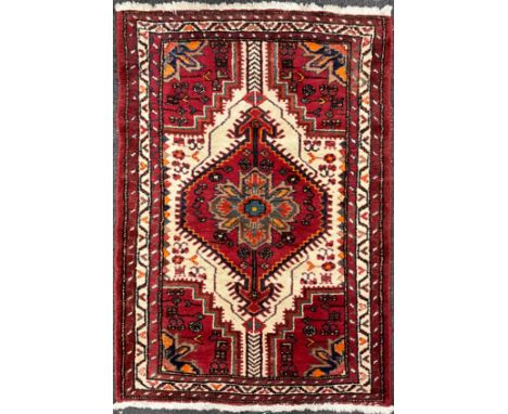 A Persian Shiraz type rug / carpet, hand-knotted in deep red, indigo, turquoise, orange, and white, 131cm x 92cm.