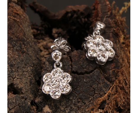 A Pair of 18ct white gold daisy-style diamond set cluster drop earrings, the central round brilliant cut stone set within a f