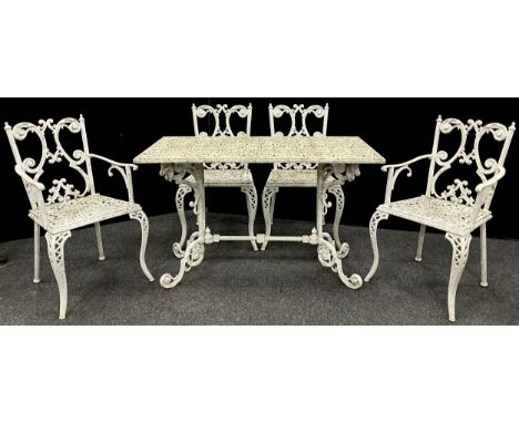 Garden furniture - A cast iron table and set of four chairs, the table having a rounded-rectangular fret-work top, scroll fee