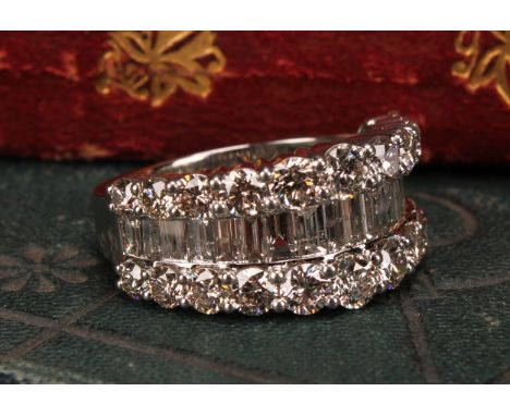 A diamond and platinum ring, the central band of baguette cut stones flanked by two rows of graduated round brilliant cut sto