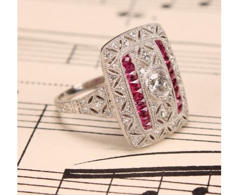 A Large Art Deco style platinum ring set with old-cut and eight-cut diamonds and rubies with milligrain detailing. Central ol