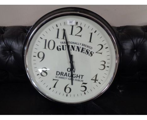 A circular wall clock bearing Guinness advertising 