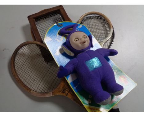A box containing late 20th century children's annuals, vintage rackets together with a Teletubby soft toy