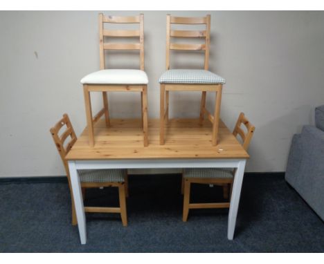 An Ikea pine top dining table on painted legs, with a set of four ladder back chairs 