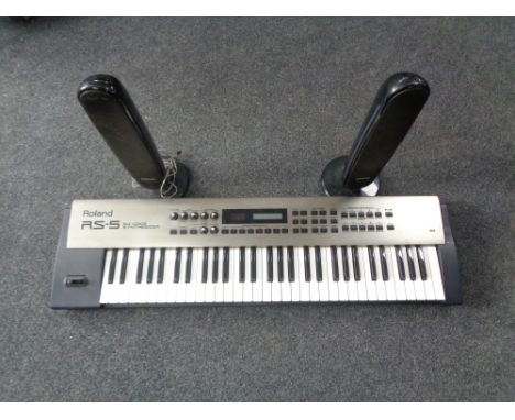 A Roland RX-5 64 voice synthesizer together with a pair of Samsung surround sound speakers 