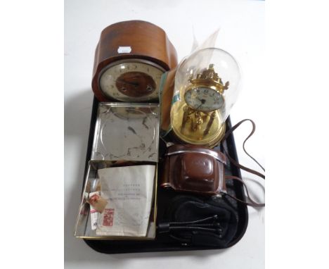 A tray containing a Kundo anniversary clock under shade, a walnut cased Smith mantle clock, camera, loose stamps, cigarette c
