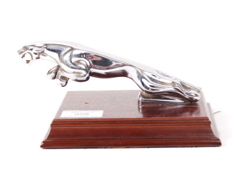 An original vintage Jaguar car mascot, chrome, mounted on a wooden display plinth. Serial number to base. The Jaguar measurin