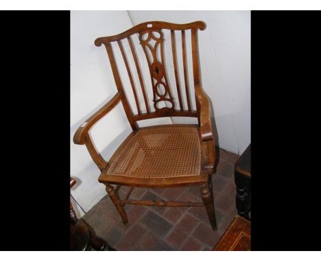 A late 19th century cane seated armchair with comb top rail