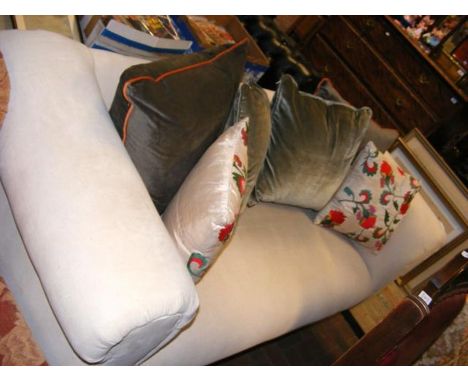 A cream upholstered scroll arm sofa with contrasting cushions