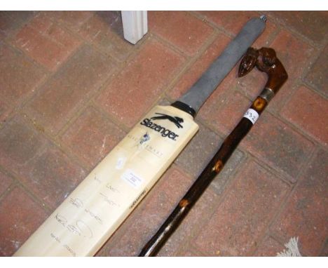 A signed cricket bat, together with a silver topped walking stick 