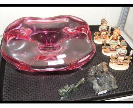 Three Hummel figures, two jade figures, together with a Murano style cranberry glass bowl 