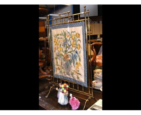 A late 19th century brass fire screen with embroidered floral panel 