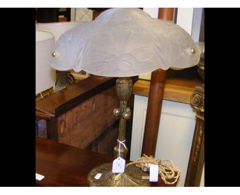 An ornate table lamp with cast metal base and glass shade 