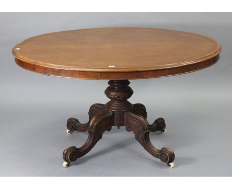 A 19th century mahogany pedestal dining table with an oval tilt-top; &amp; on a carved vase-turned centre column &amp; four c