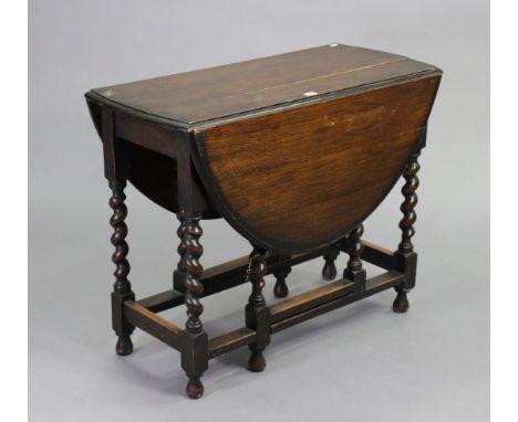 A 1930s oak oval gate-leg dining table on barley-twist supports, 35½” wide x 28” high; a beech standard lamp with a fluted ce