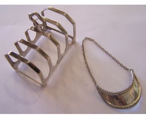 A silver four division Toast Rack, Sheffield, 1934 and a silver crescent shape decanter label.